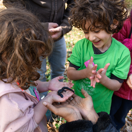 Two kids holding a salamander